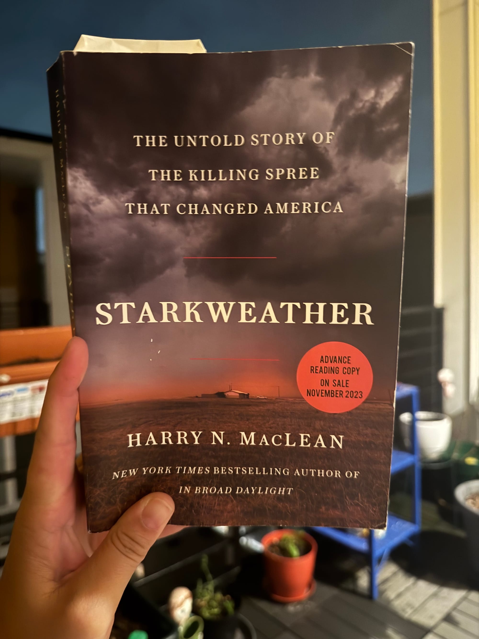 hand holding the book "starkweather" by harry n. maclean